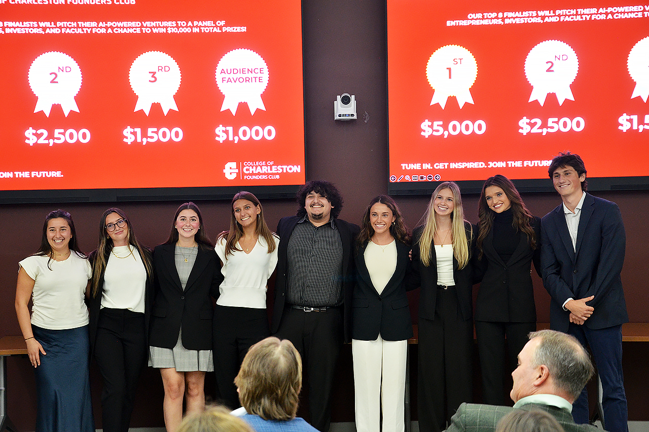 Nine students standing on stage and smiling