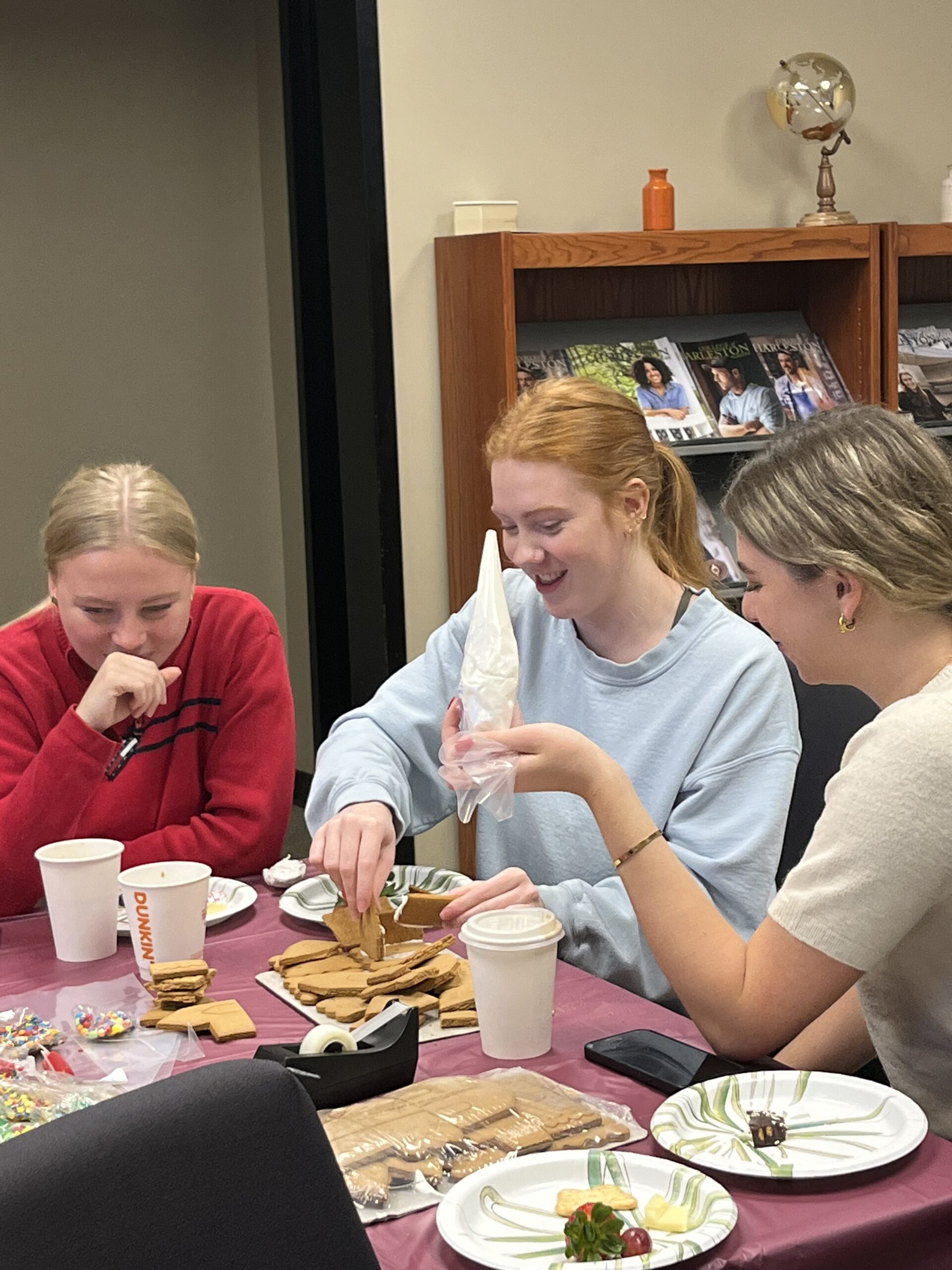 international students make gingerbread houses