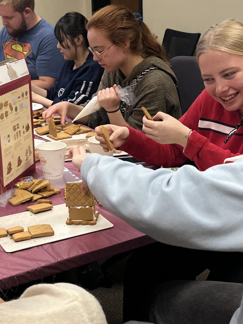 international students make gingerbread houses