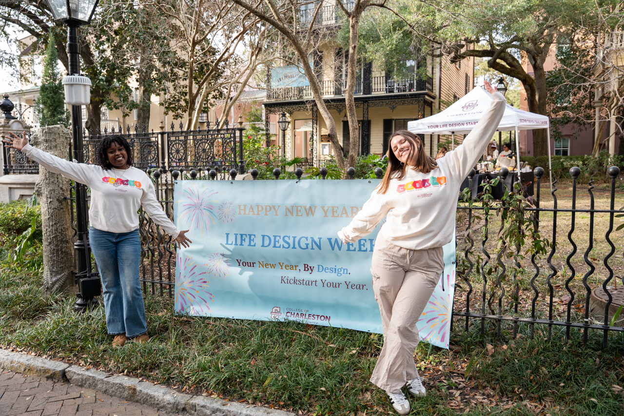 Two women stand in front of a sign at the Life Design Center
