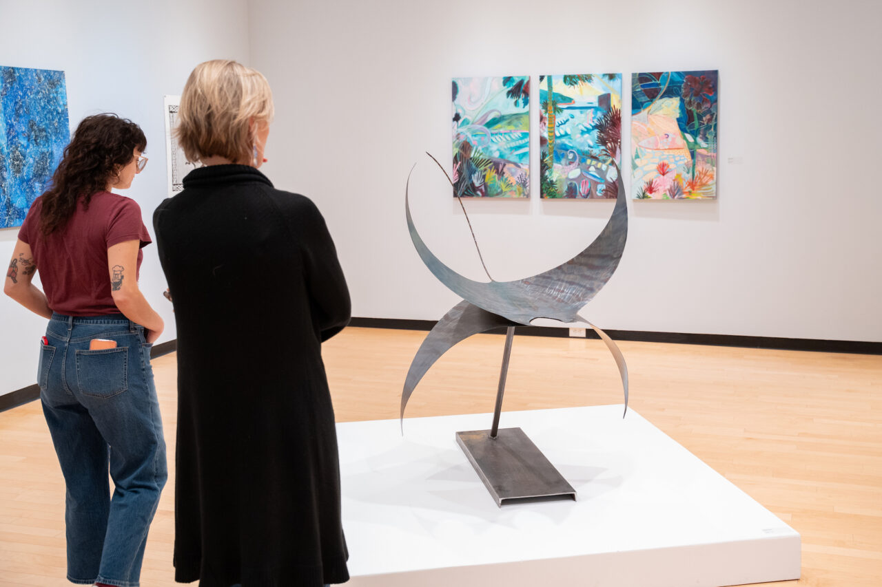 two women looks at sculpture of manta ray