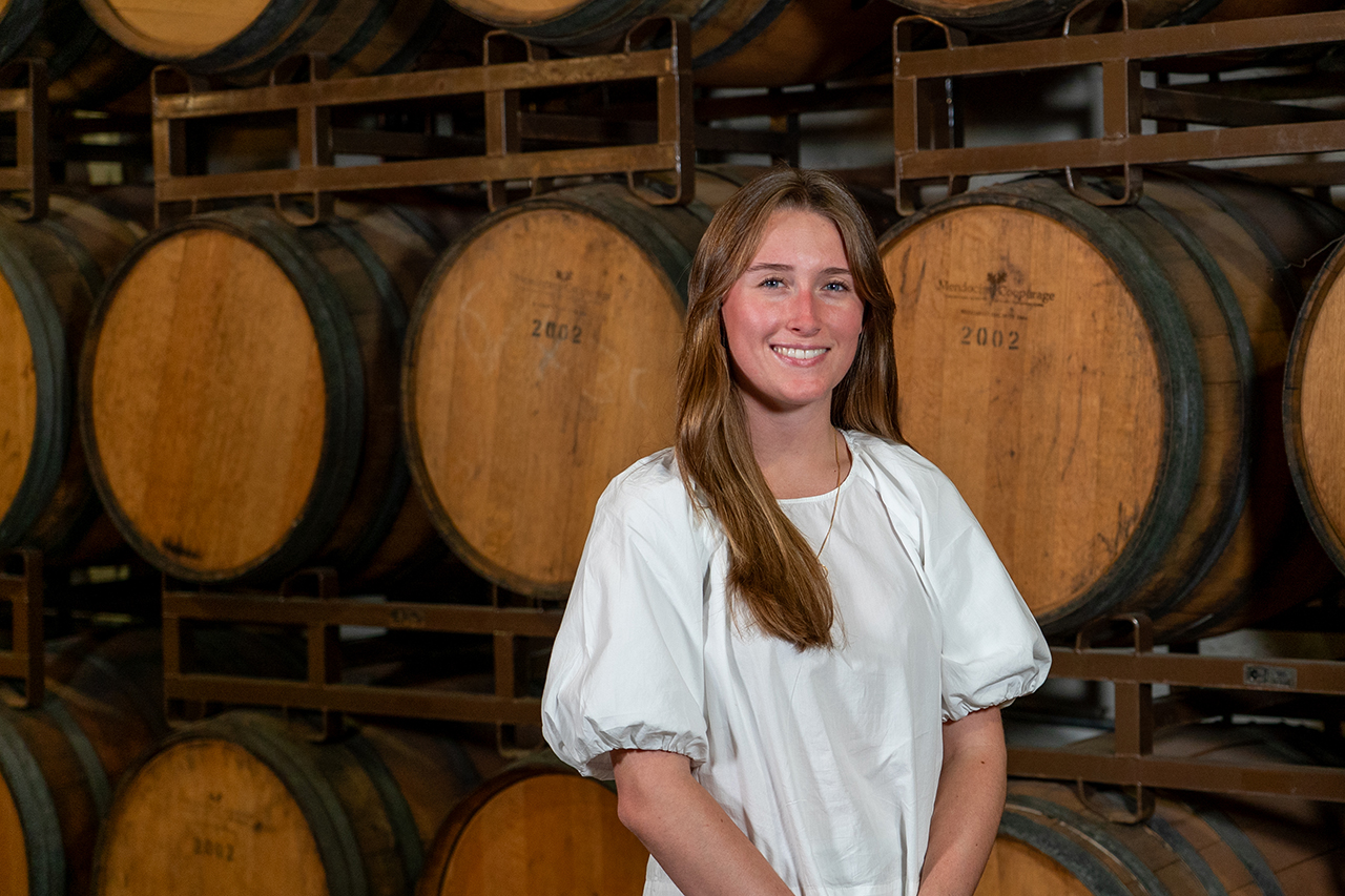 woman in front of wine barrels