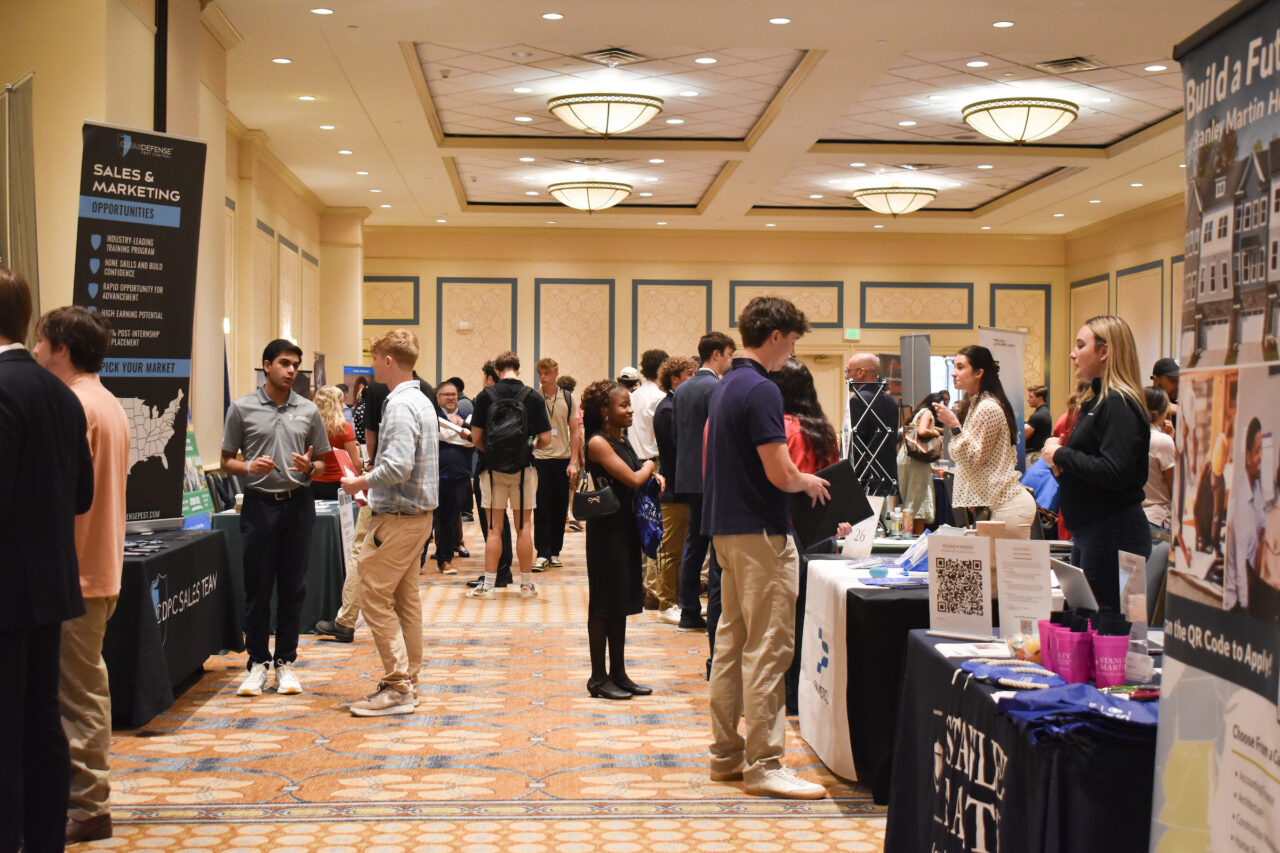 wide photo of career fair showing room with students and employers