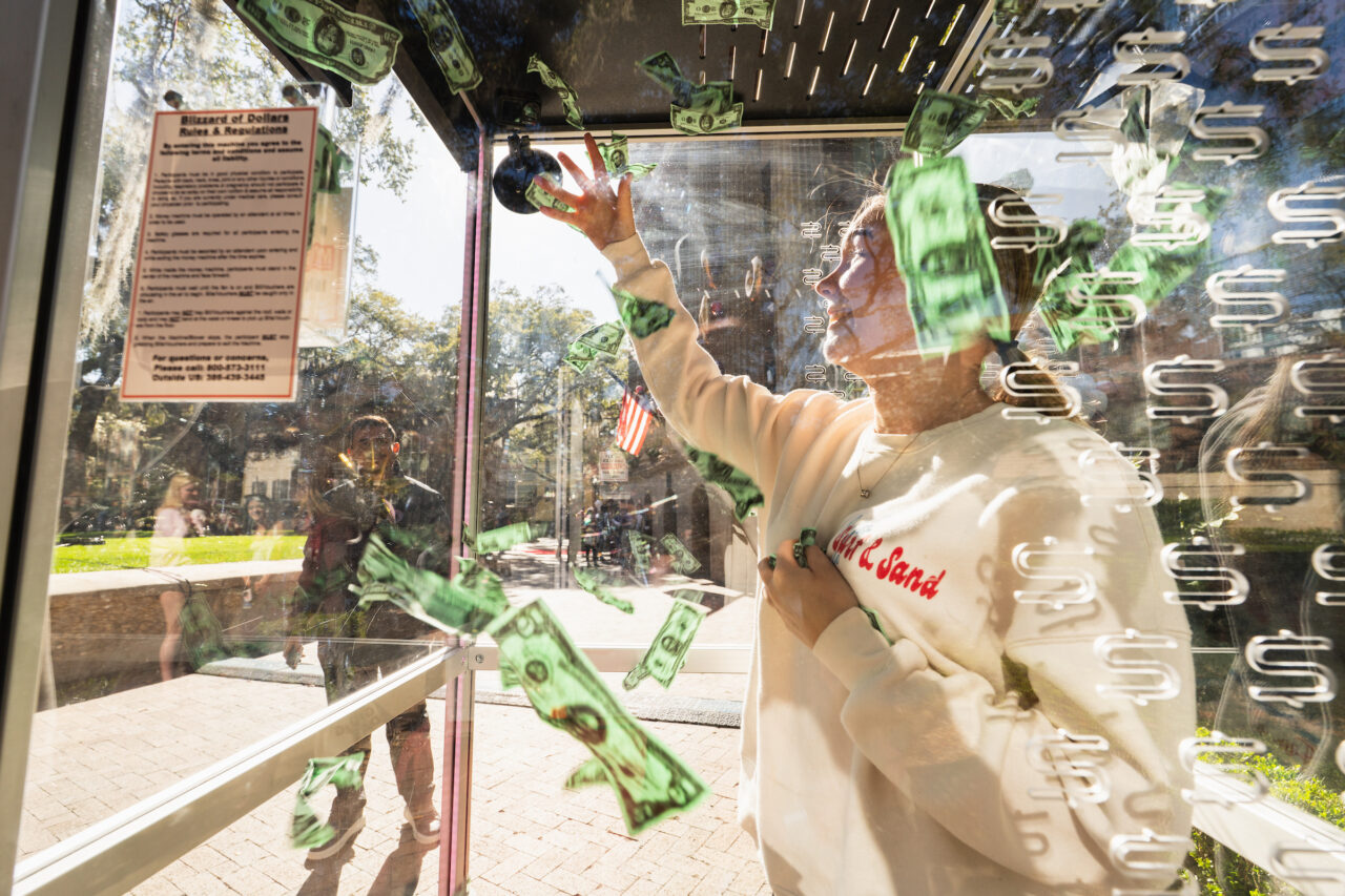 student in cash grab machine