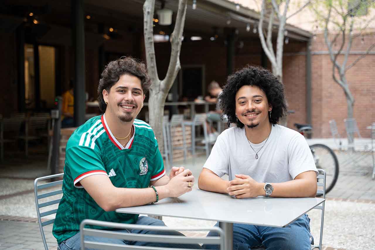Manny Contreras-Ramirez and Jalen Evans smile at camera 