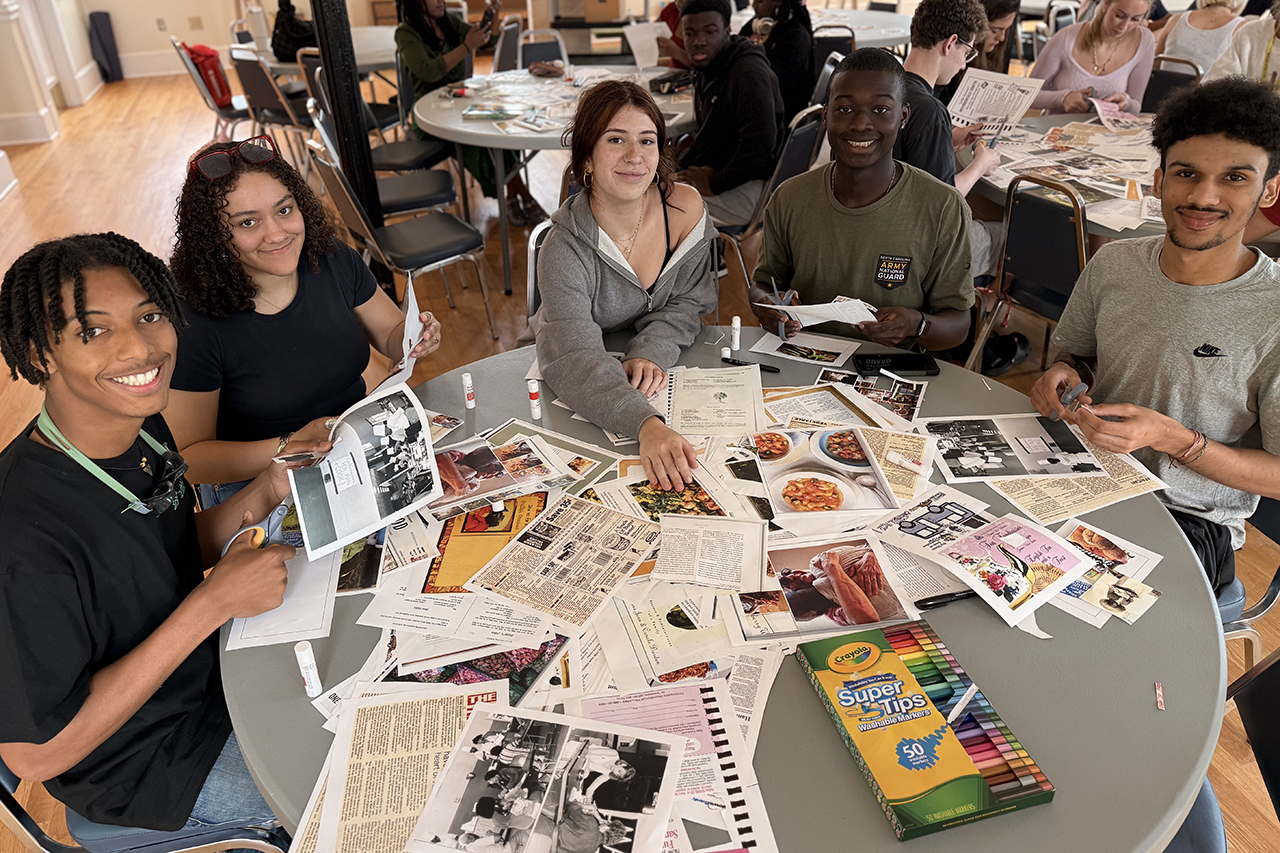 students sitting around a table with art supplies