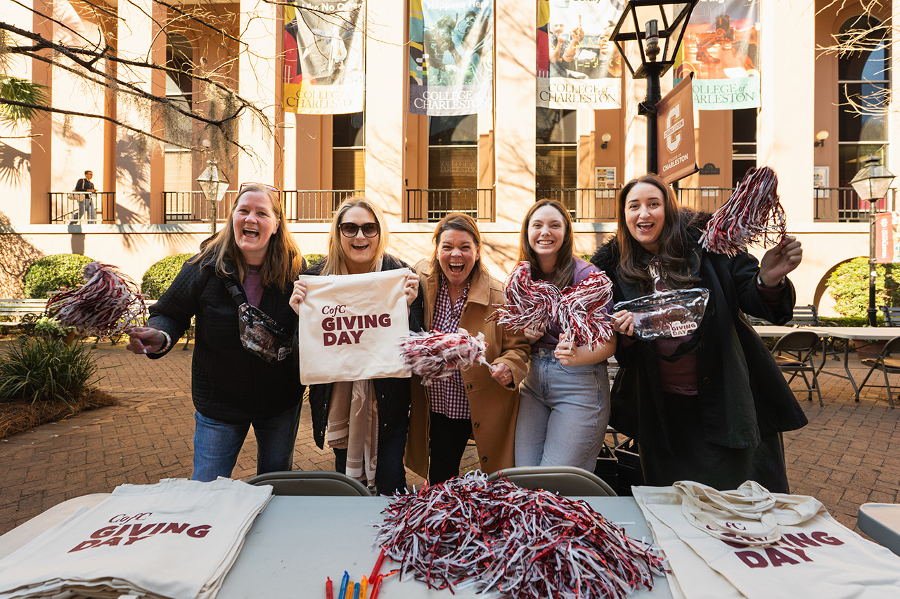 women show excitement as they hold CofC Giving Day gear