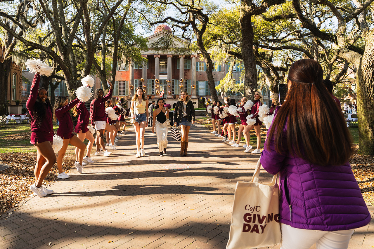 cofc spirit squad lines the sidewalk as people walk through the cistern yard