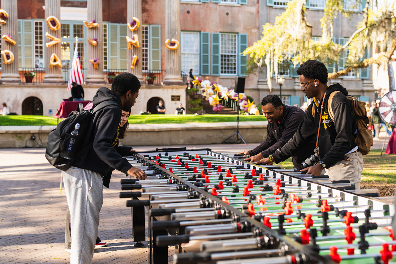 people play on a giant foosball table