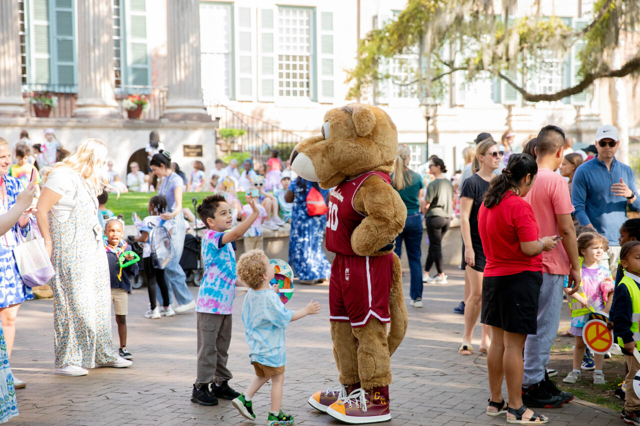 Clyde the Mascot Cougar high fives children