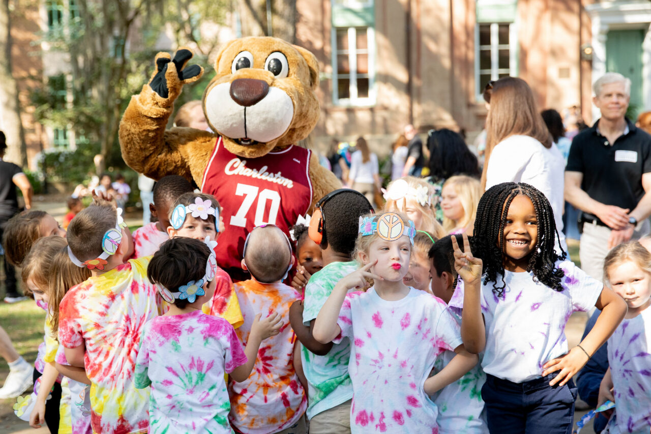 Children hold up the peace sign with Clyde in the background