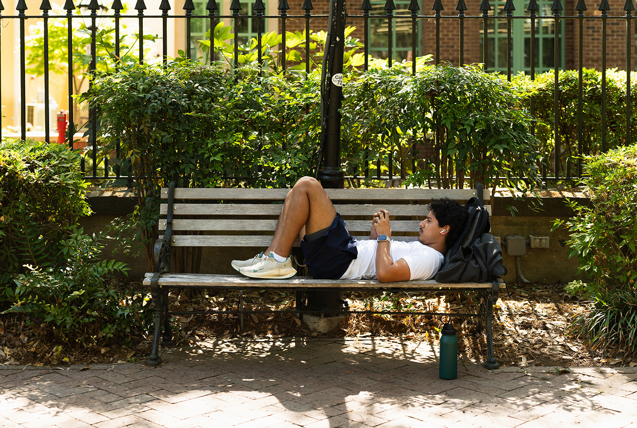 student takes a rest on park bench