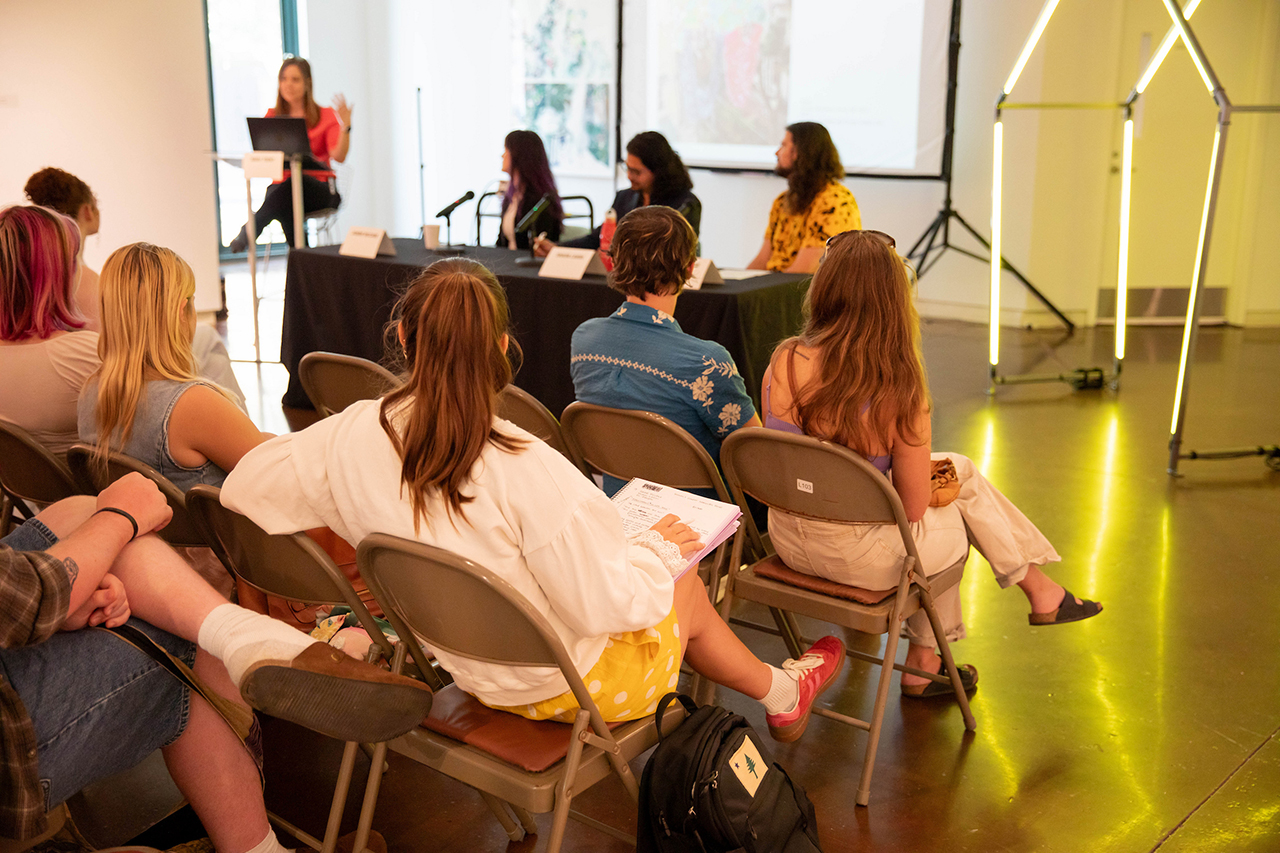 students look at speaker in gallery space