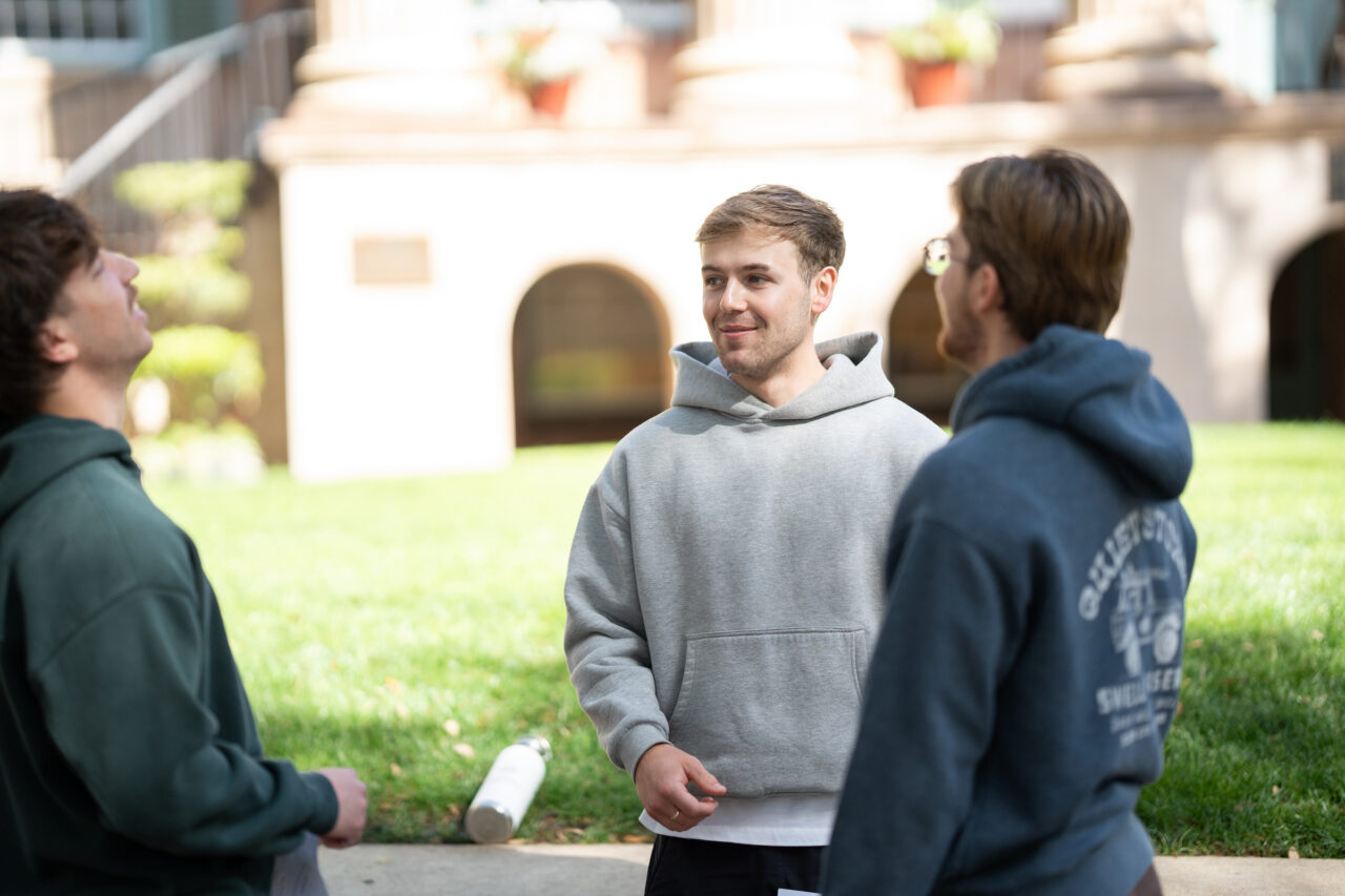 three male students talk about classwork
