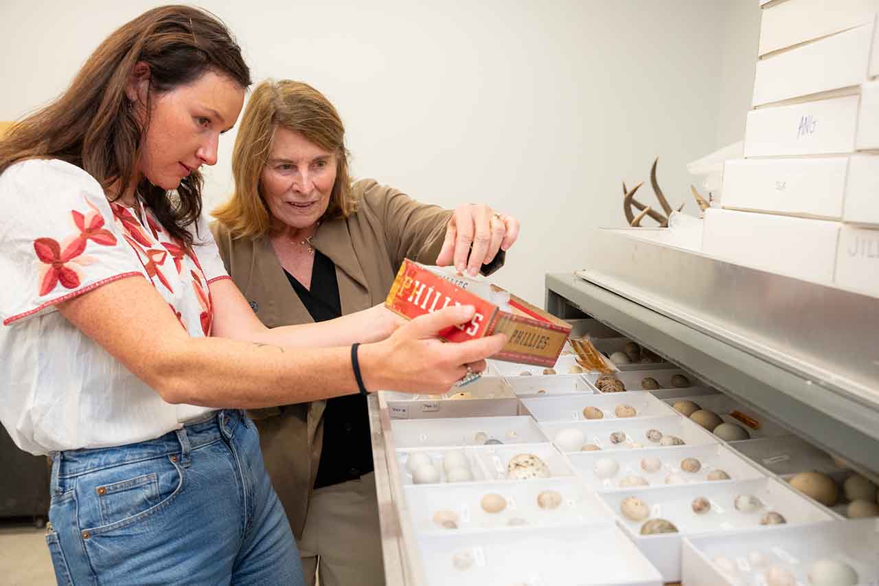 madison cantrell and mary rivers look at bird eggs