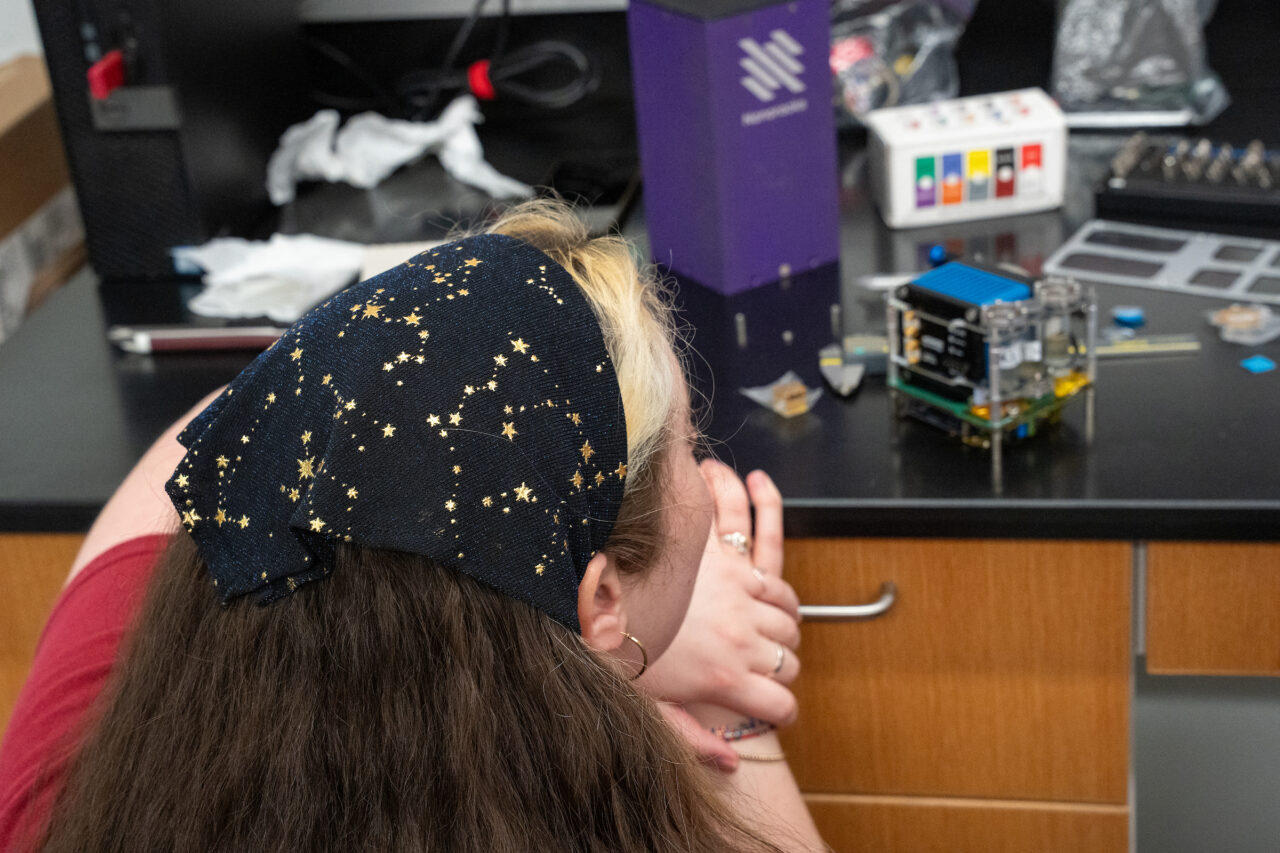 Woman with head scarf with consolations looks at payload
