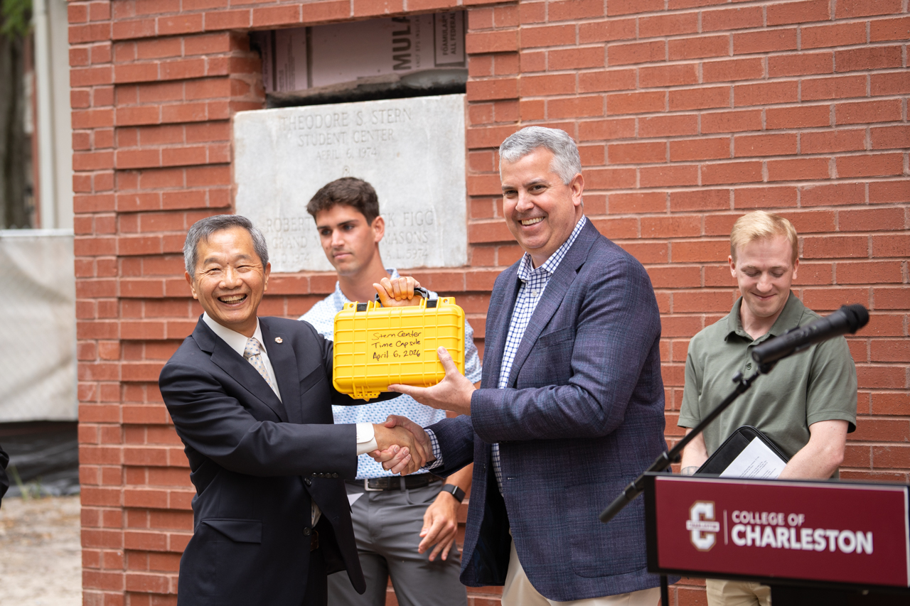 President Hsu shakes hands and holds up Time Capsule