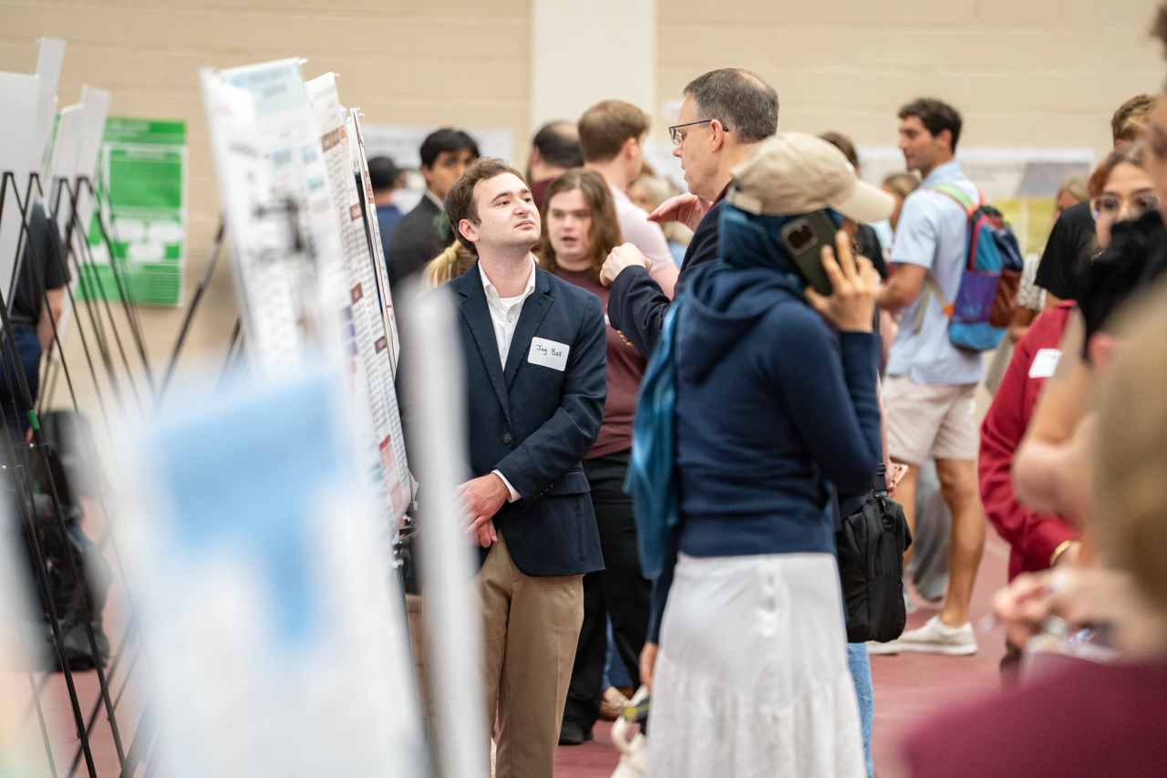 student looks up among all the other posters