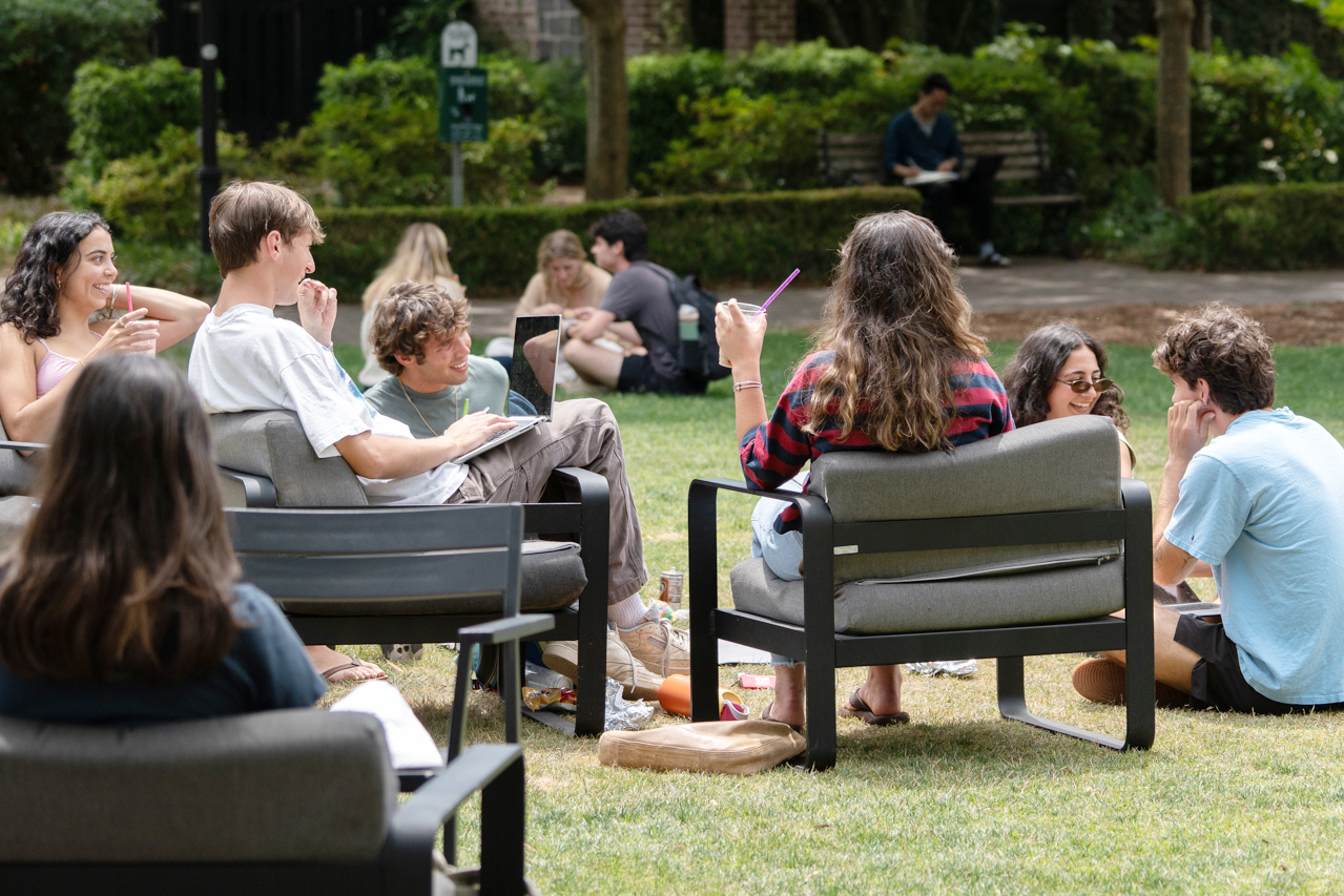 Students relax and laugh with friends in Rivers Green