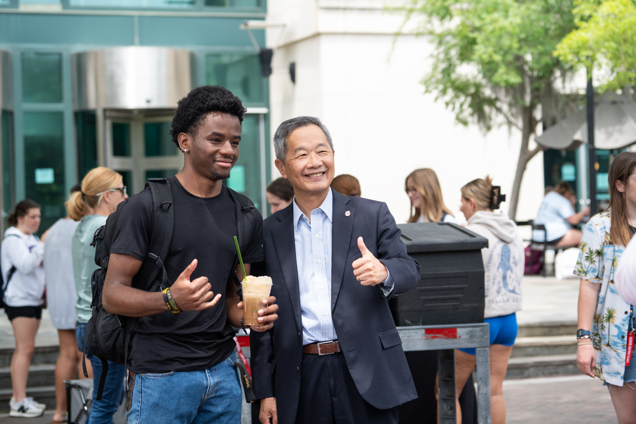 Student and President Hsu hold thumbs up