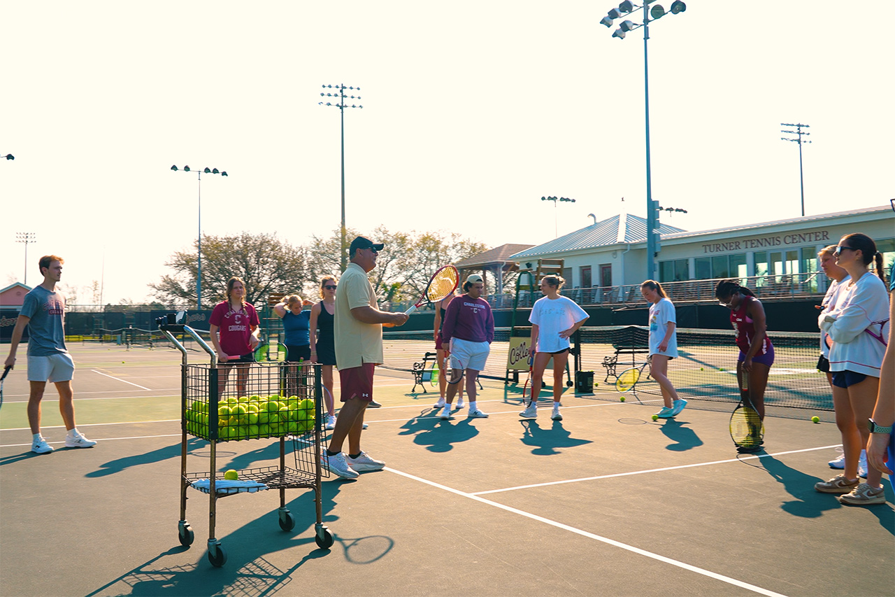 Instructor talking to tennis students