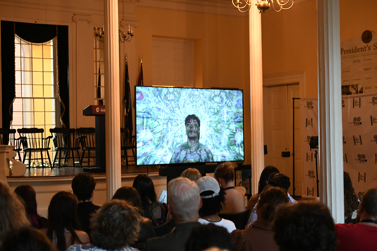 people watching a movie on a screen in Alumni Memorial Hall