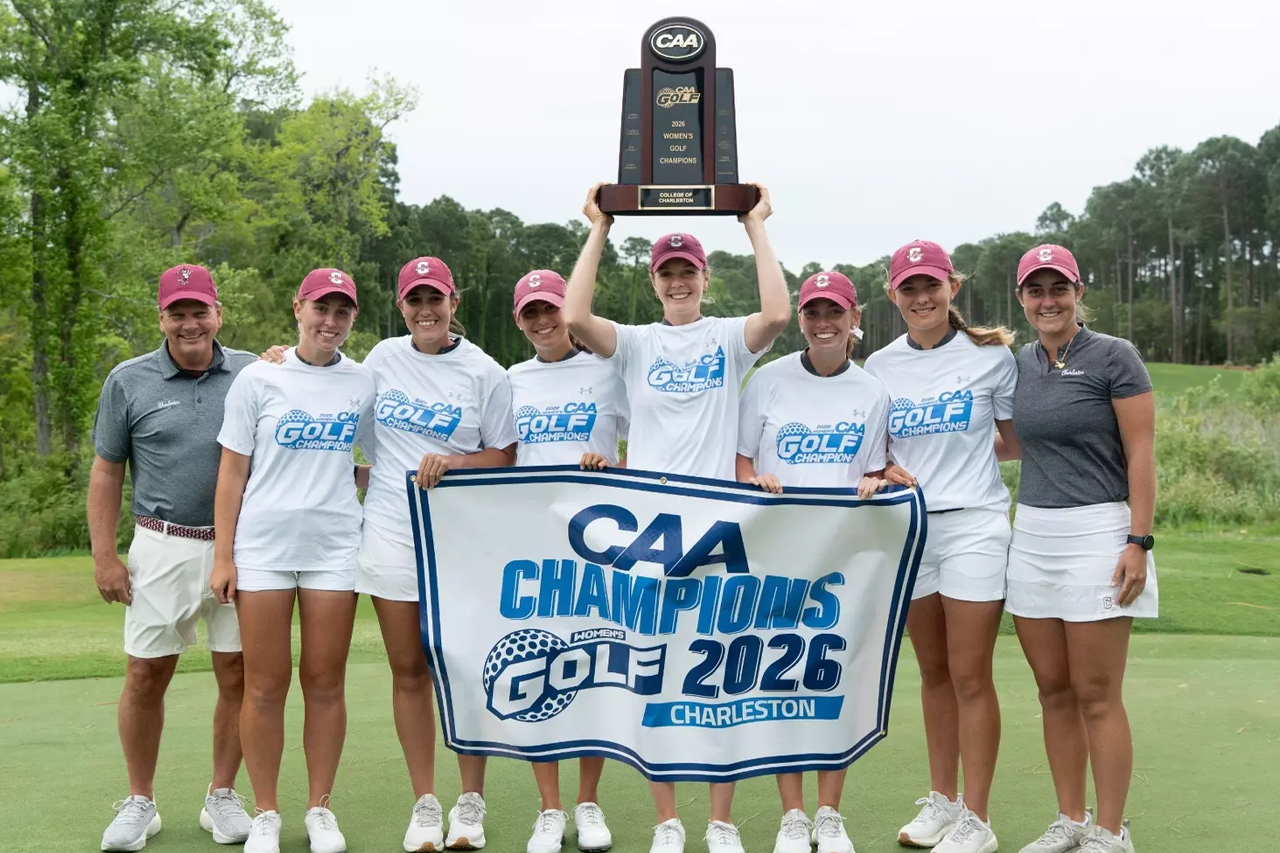 golf team holds trophy and flag to celebrate win