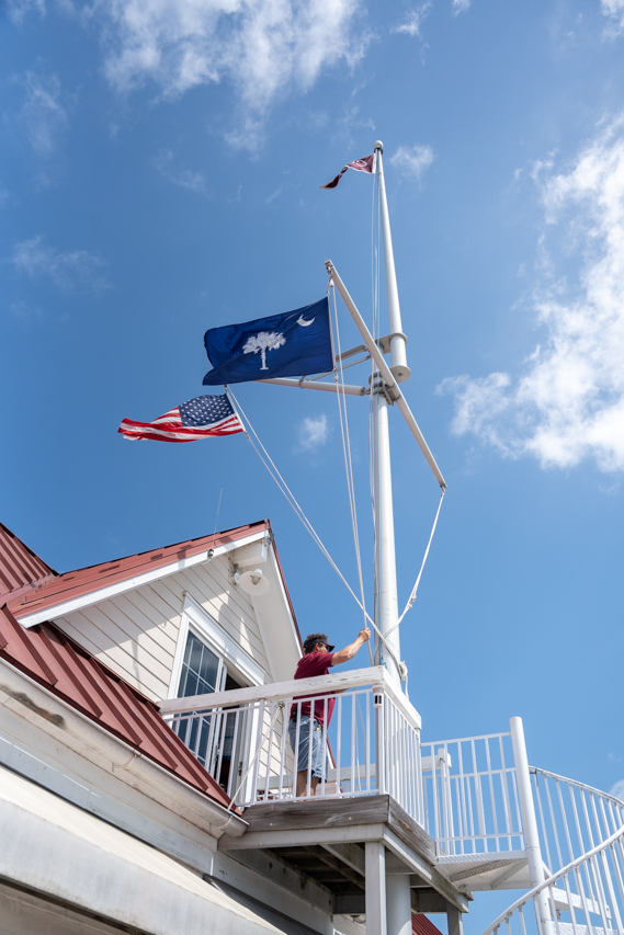 flag pole has sc flag with palm tree and moon