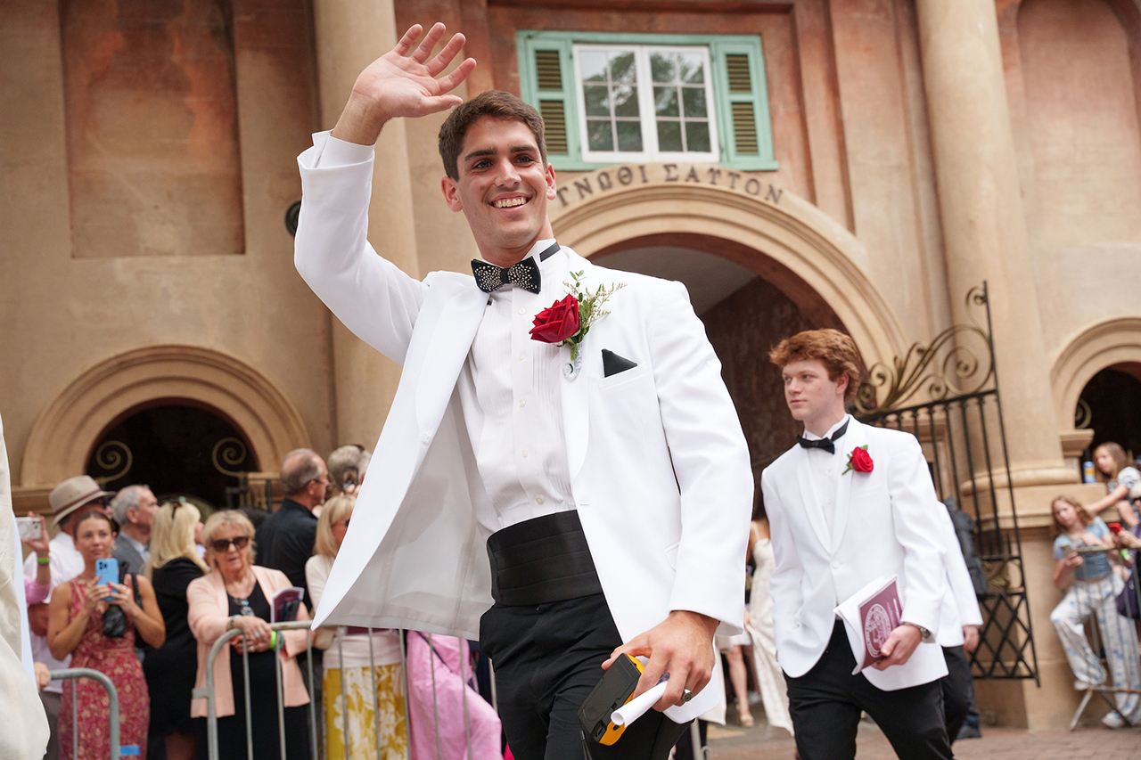 man waving at commencement