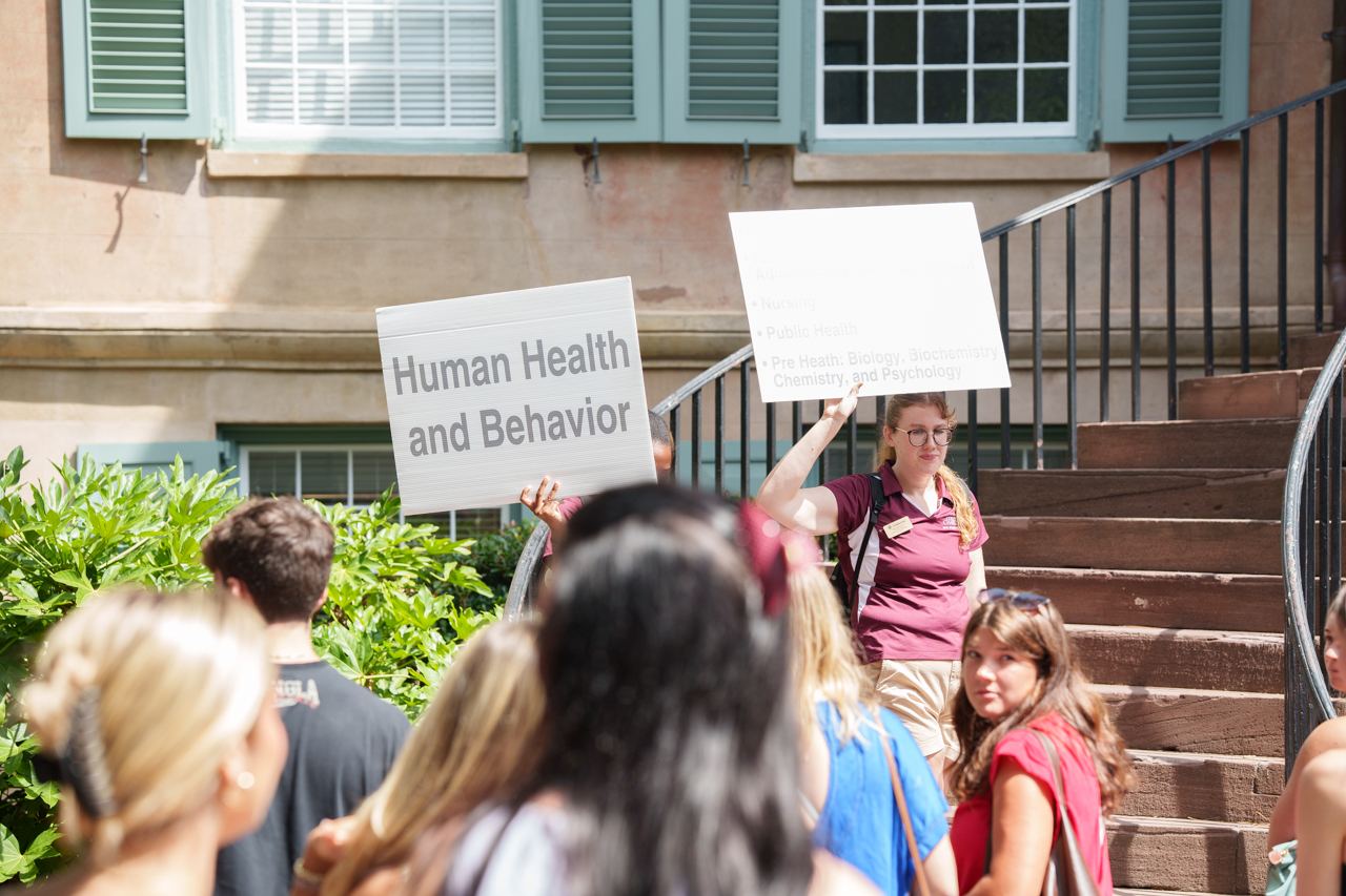 student orientation volunteers hold up signs