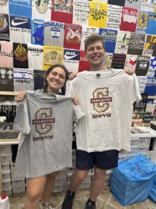 Alli Fransblow with her high school friend, incoming CofC freshman Jordan Solom, holding up CofC shirts that say Charleston in Hebrew
