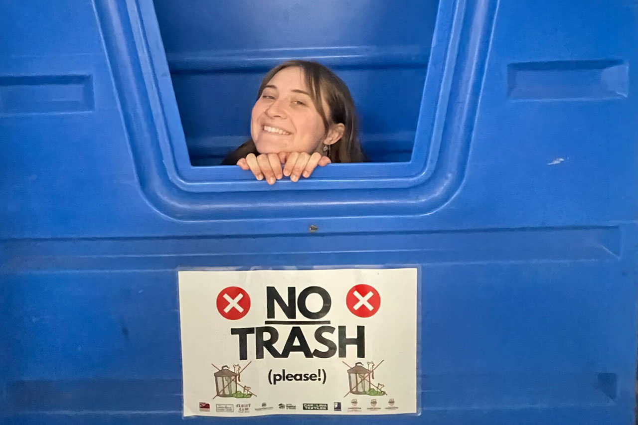 girl sitting in recycling container