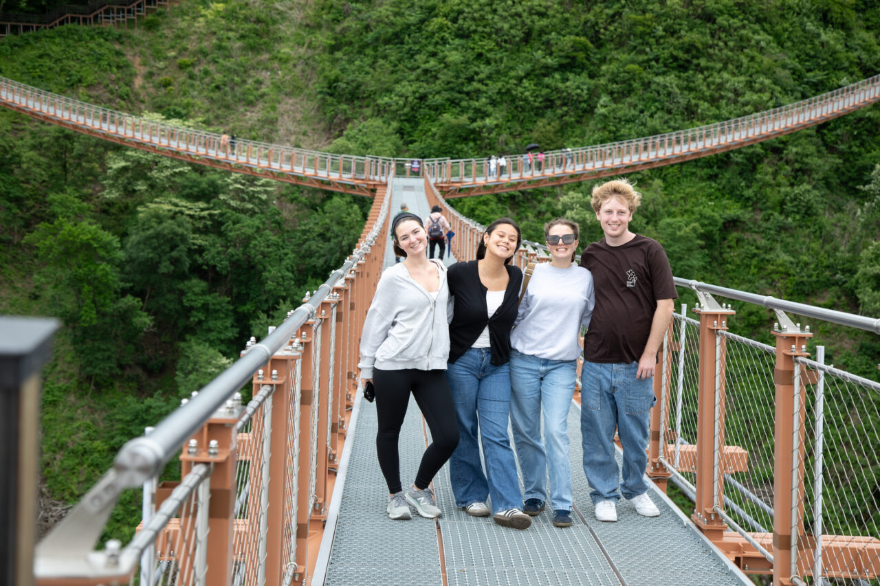 Students pose together on a bridge in South Korea