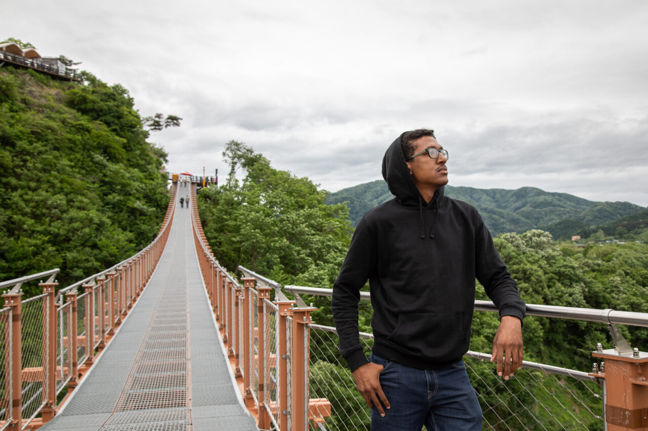 Male Student poses on bridge in South Korea