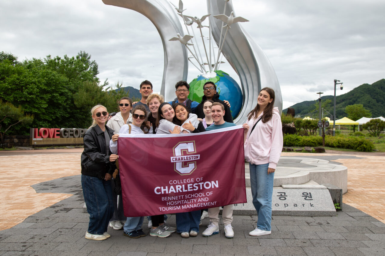 Group Photo of Abroad study in south cores holding up College of Charleston sign