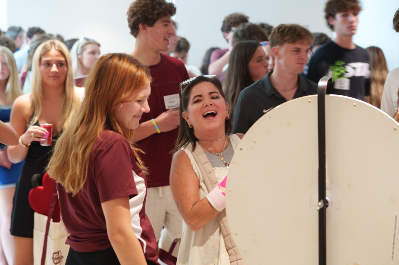 woman laughs while spinning a prize wheel