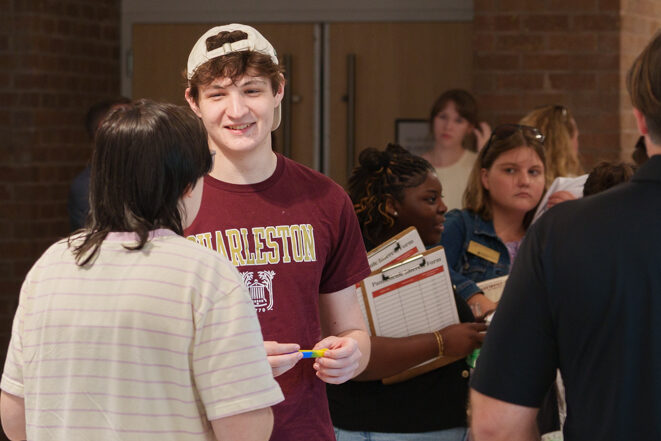 student with college of Charleston shirt chats with another student