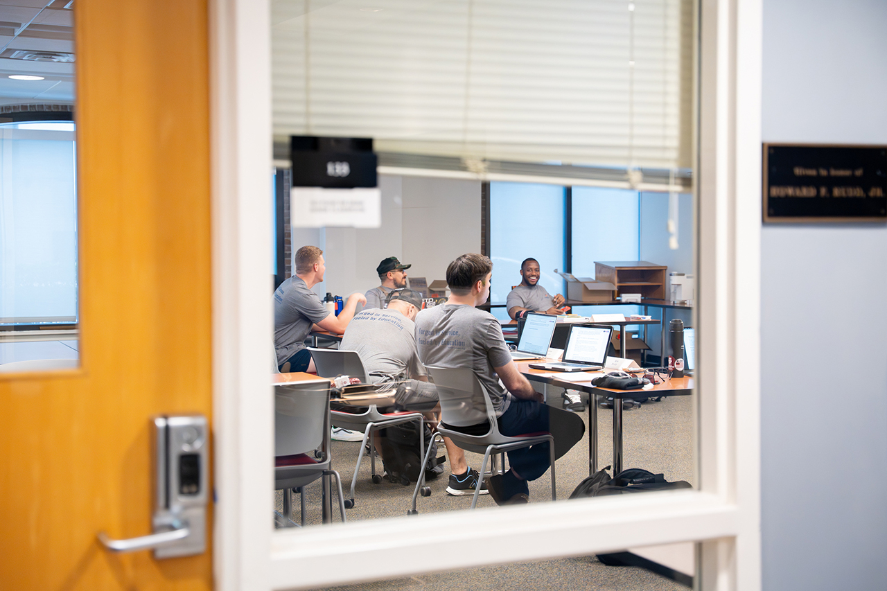 Warrior Scholars program taking place in a classroom, photo is view looking in from glass door