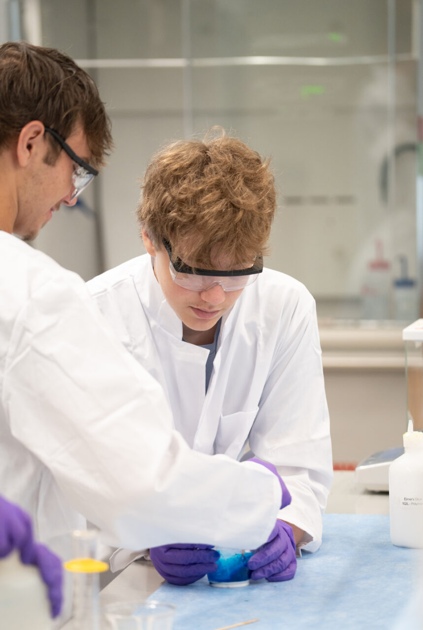 Two students work together in lab coats