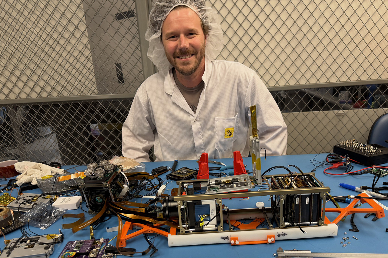 Kevin Gainey smiles with a bunch of equipment pieces