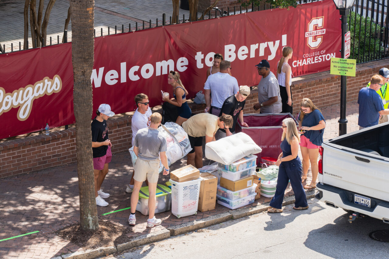Students unload boxes and belongings from a truck near a “Welcome to Berry!” banner at the College of Charleston.