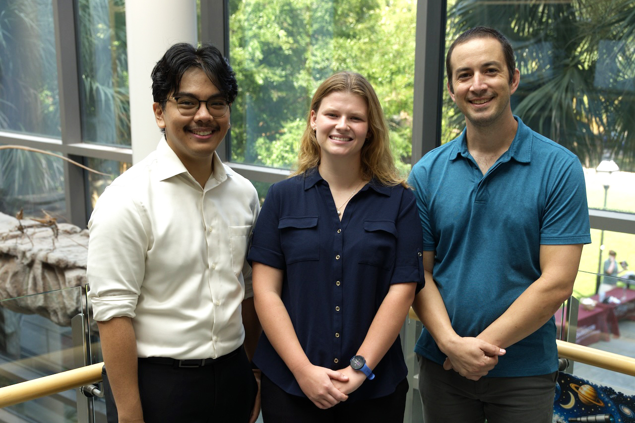 three individuals smiling at camera