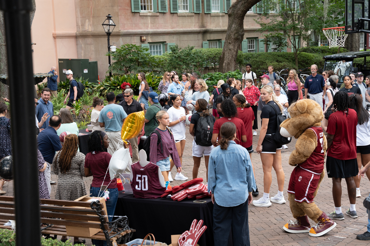 crowd gathering around basketball hoop and team