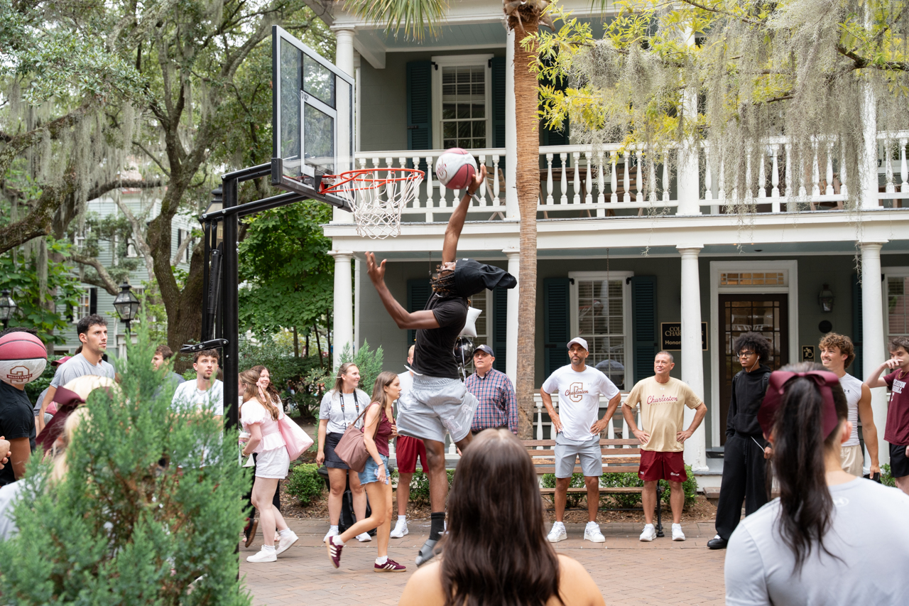 Student dunks basketball outside
