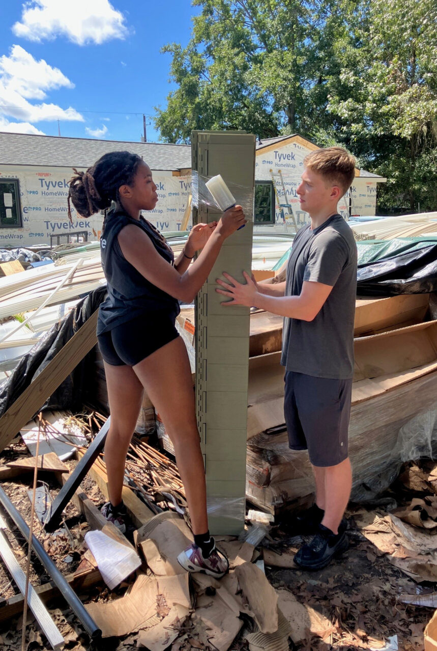 students work together holding a pole